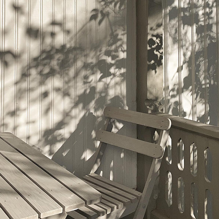 Målad veranda och målade trädgårdsmöbler.