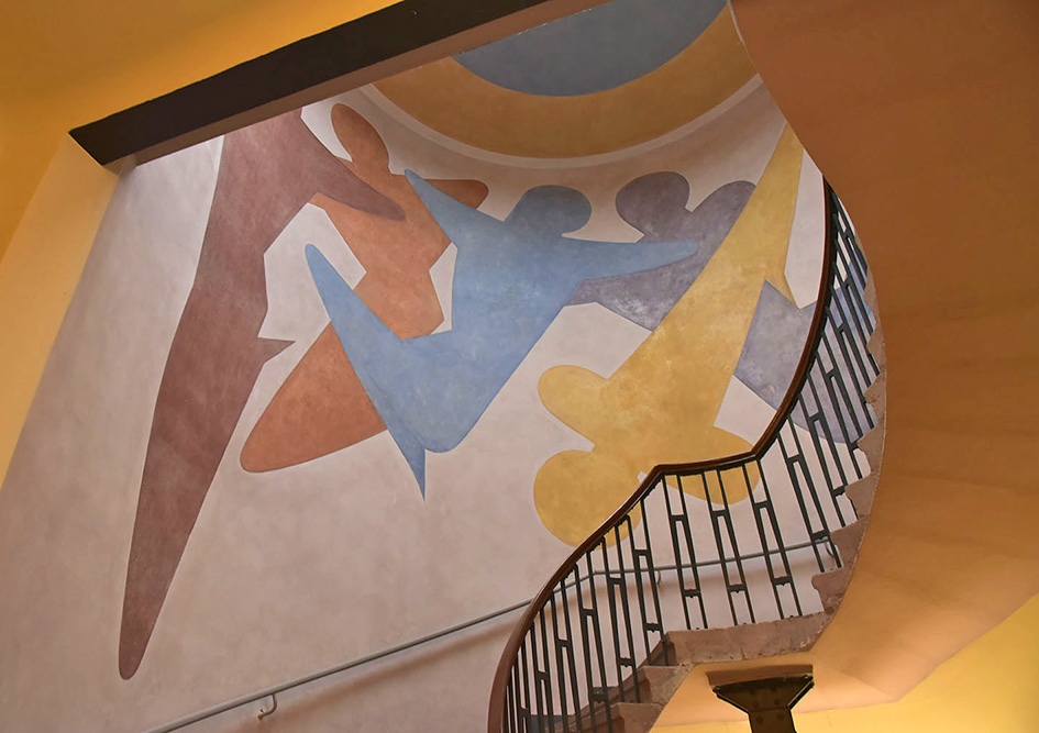 Trapphus med väggmålning med ett abstrakt mönster föreställande människosiluetter.