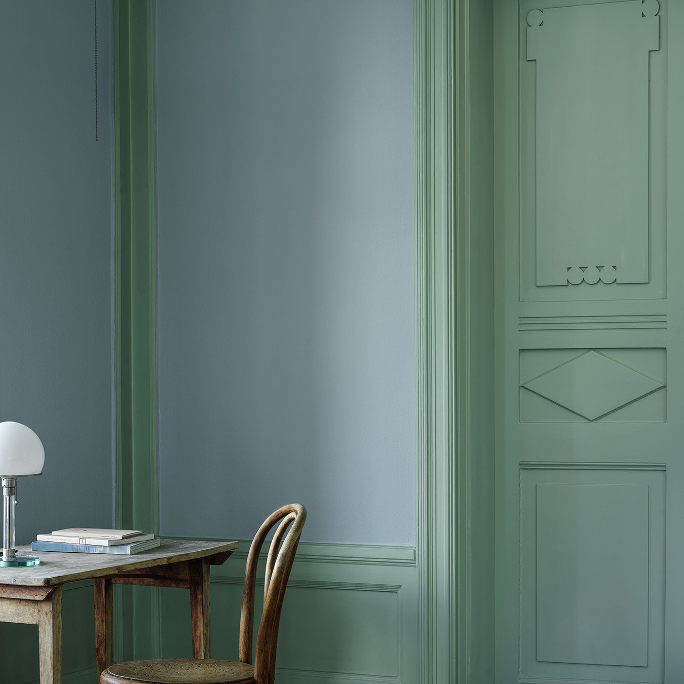 Ett rum som målats i en harmonisk blå, kulör Mildblå med snickerier, spegeldörr och bröstpanel i grön, kulör Tall.