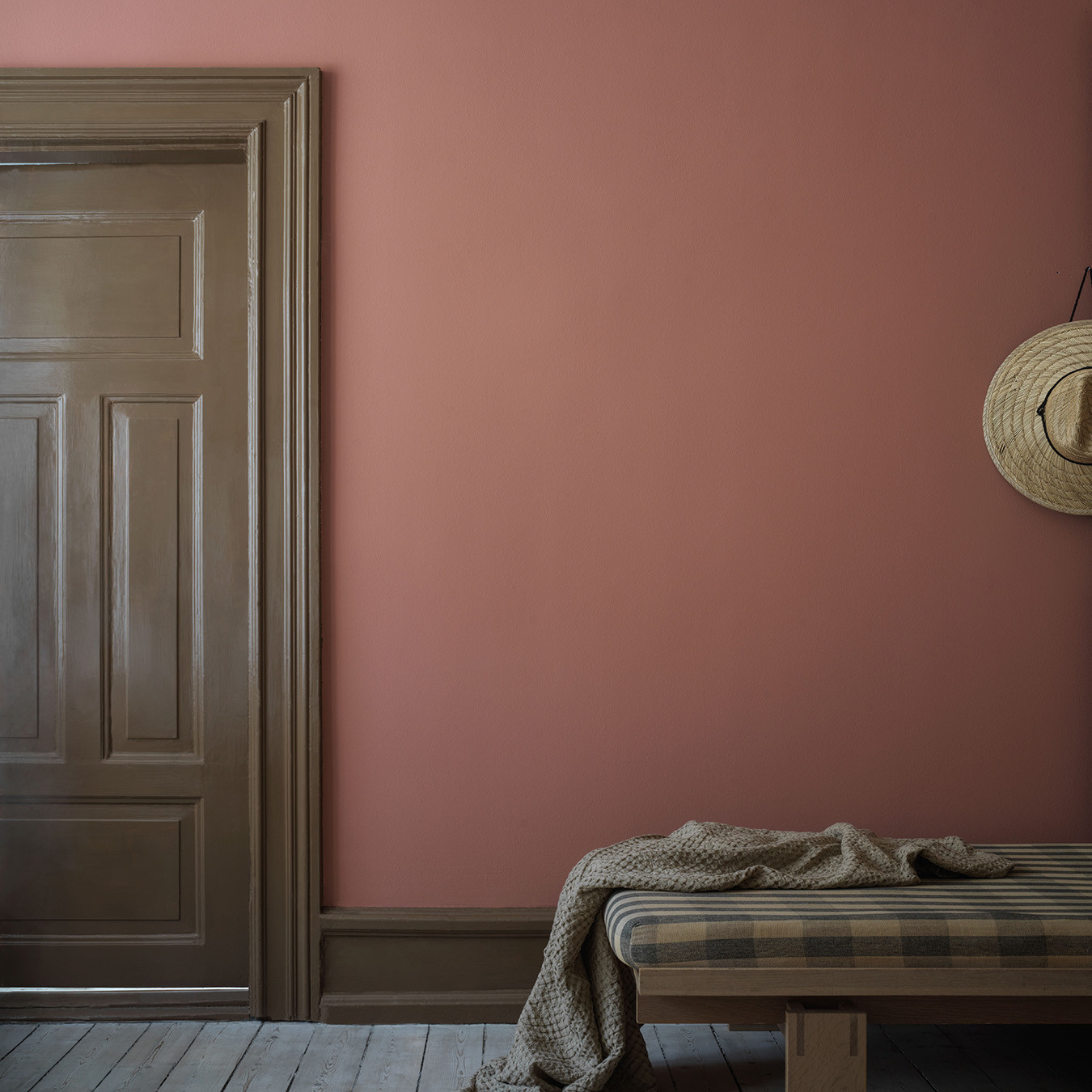 Ett rum har målats i en varm röd ton, kulör Bauhausröd medan snickerier och spegeldörr målats i en blank, brun färg, kulör Tall.