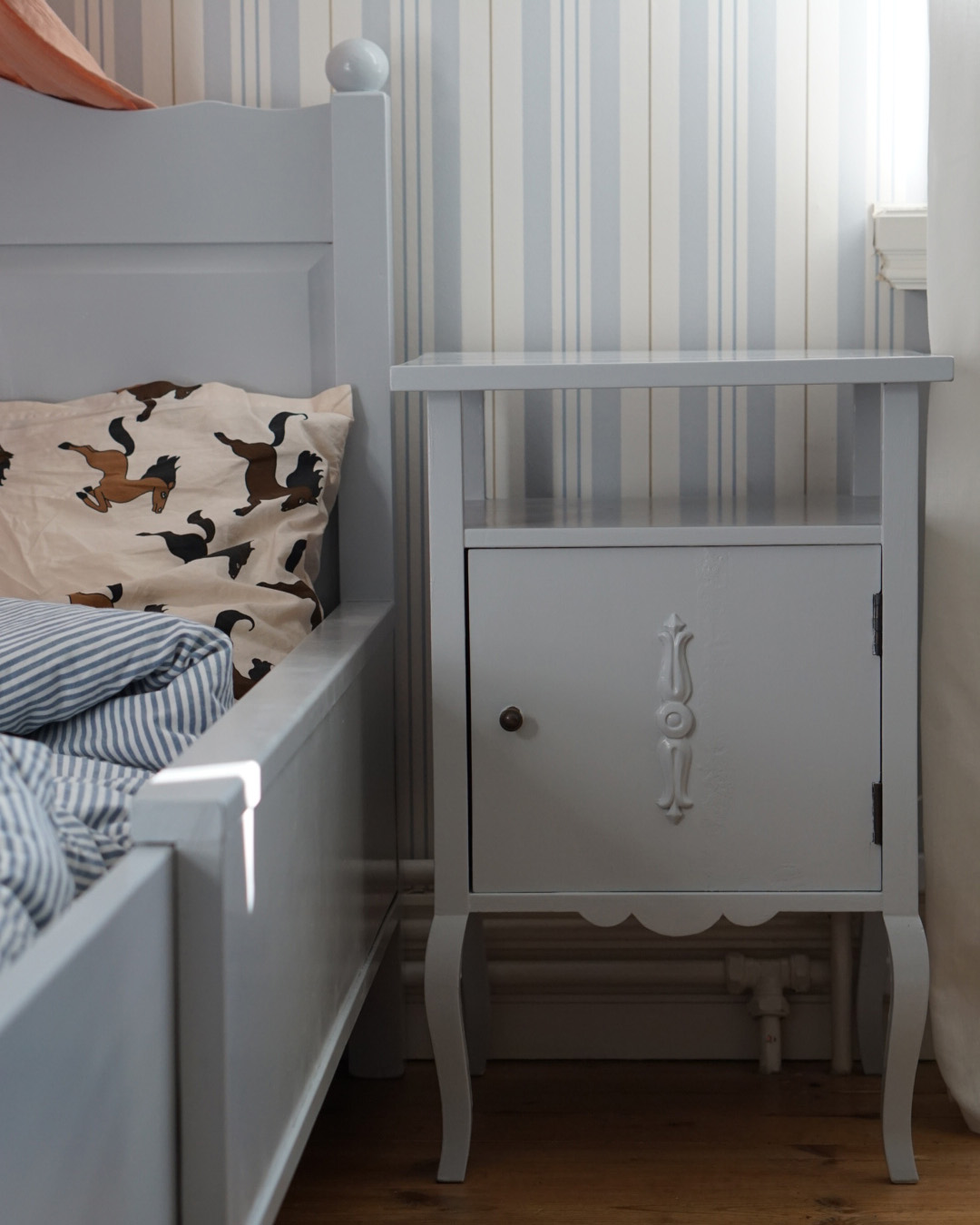 Ett barnrum med säng och sängbord gråmålade med snickerifärg från Auro.