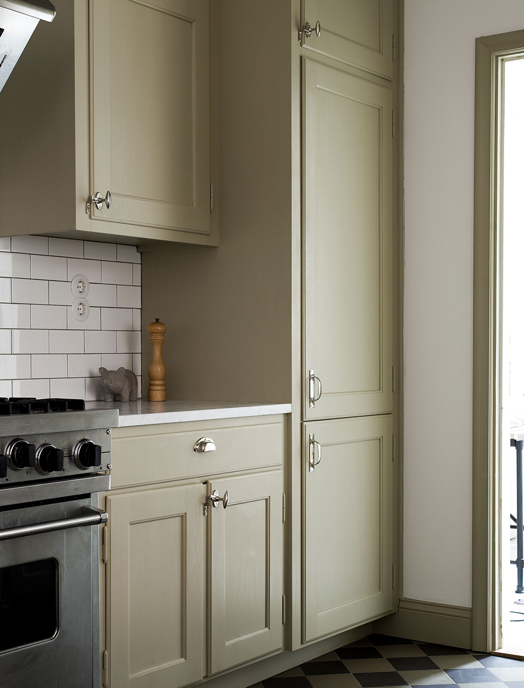 Måttbyggt kök målat med linoljefärg, kulör Vetegrå och försett med beslag i förnicklad mässing.