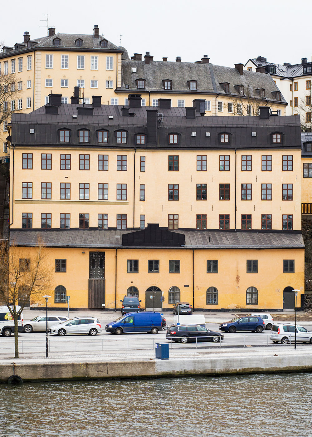 Ljusgult putsat hus med röda träfönster.